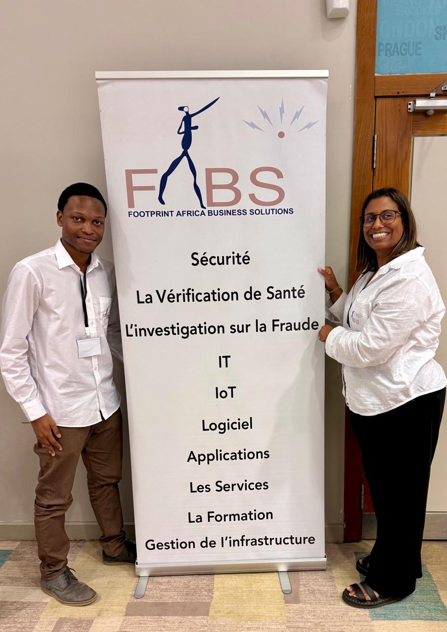 Two FABS team members beside the FABS banner